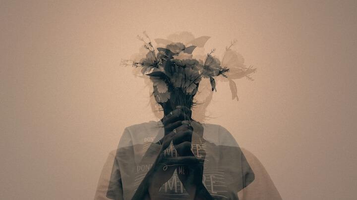 Symbolisierung Overthinking. Das Bild von Teena Lalawat stellt eine Frau mit einem Blumenstrauss vor dem Gesicht dar. Es ist eine Mehrfachbelichtung.